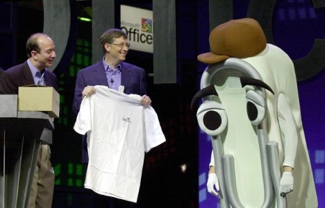 Microsoft CEO Bill Gates, center, presents a T-shirt as a retirement gift to Clippy as Amazon CEO Jeff Bezos watches at the Office XP launch